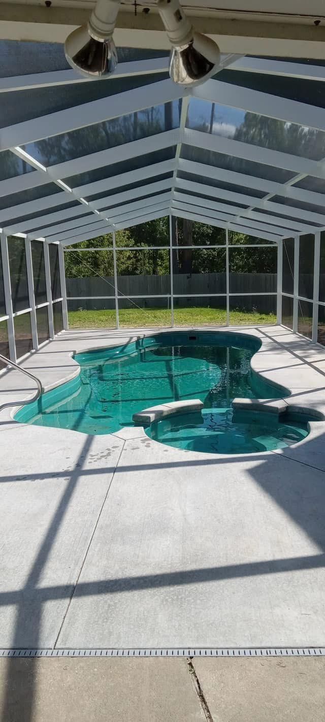 Inside a white-framed pool screen enclosure over a pool and spa