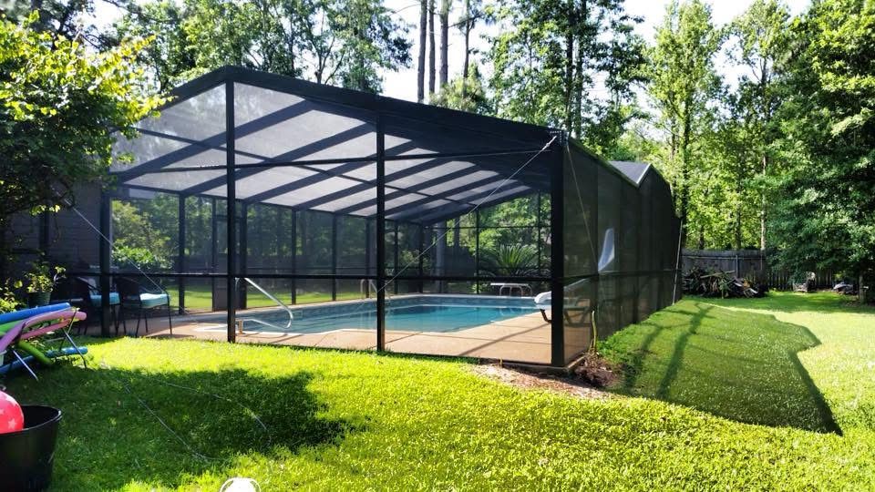 Dark bronze screened pool enclosure across a green lawn