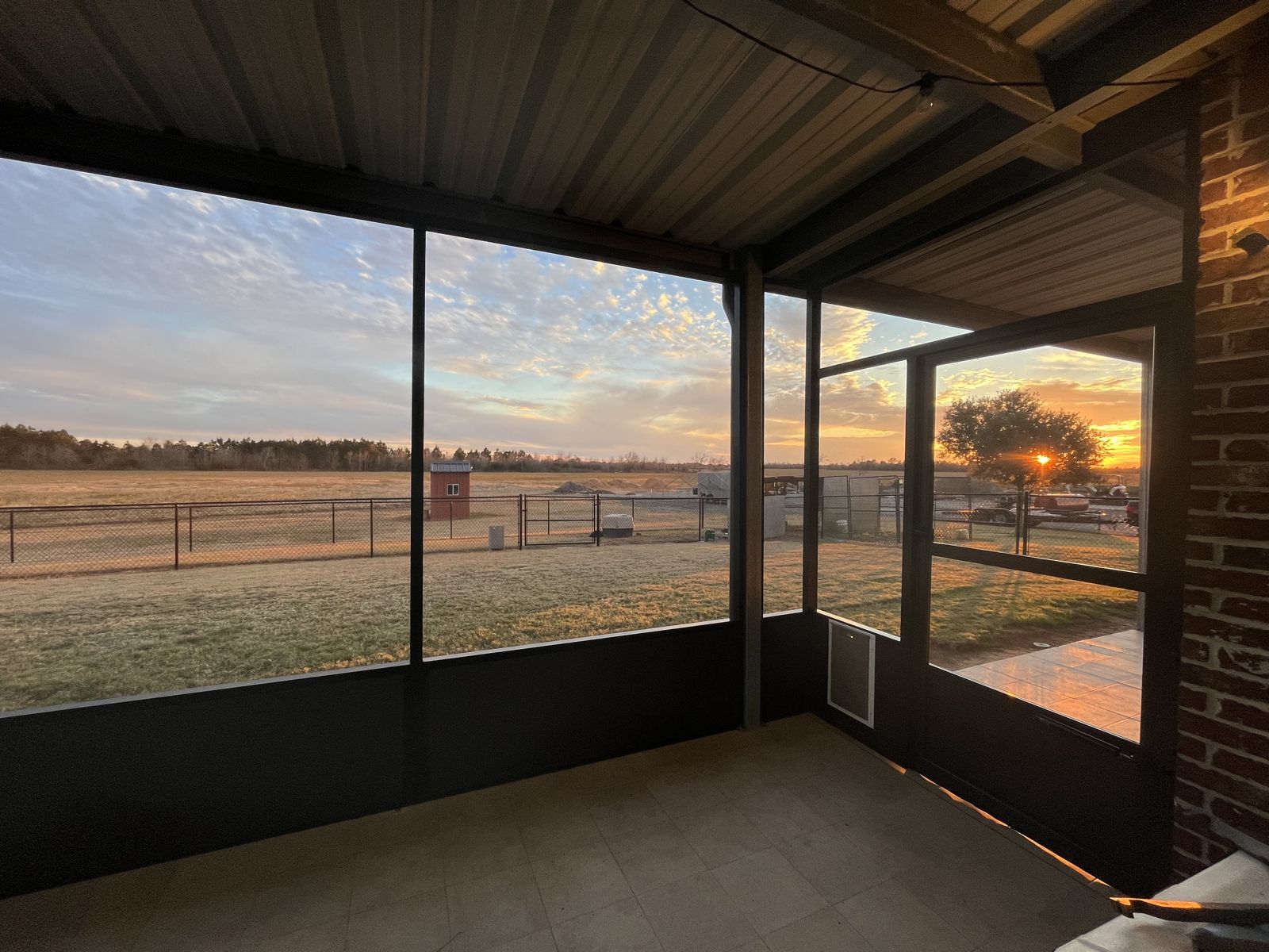 Screened porch interior with kick panels looking out at sunset