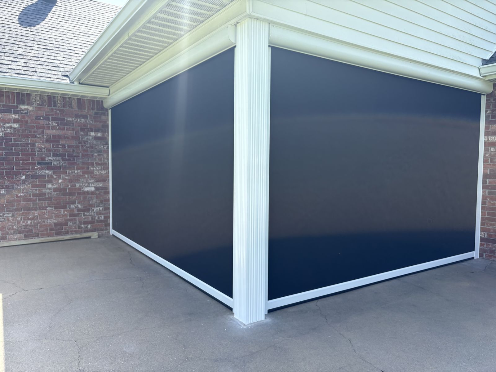 Dark shades on a corner patio with white columns